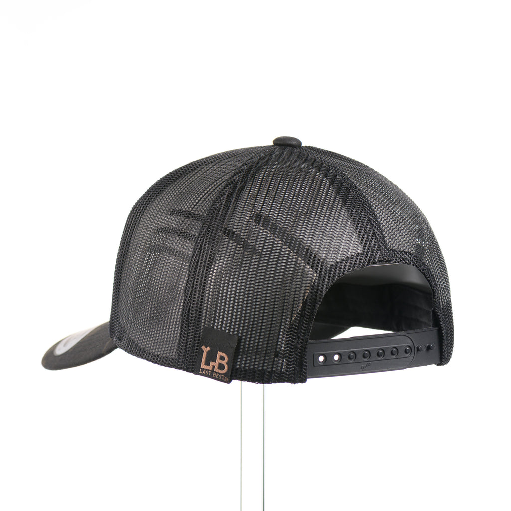 The back of a dark multicam trucker hat with a flexwood steer skull patch.