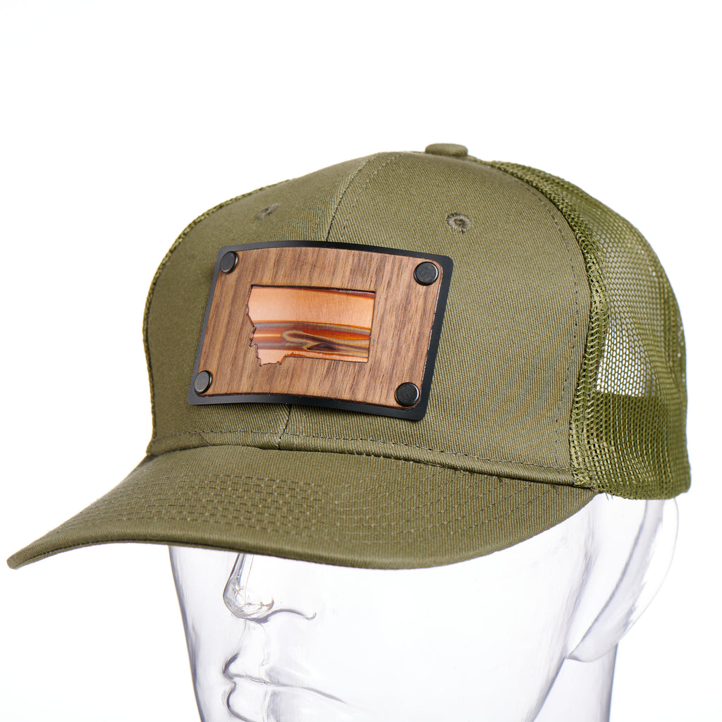 A Montana silhouette walnut wood and copper plate patch, treated to an olive green trucker hat