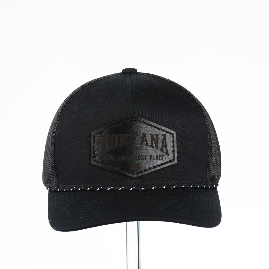 Black trucker cap with Montana The Last Best Place Leather Patch logo on a white background